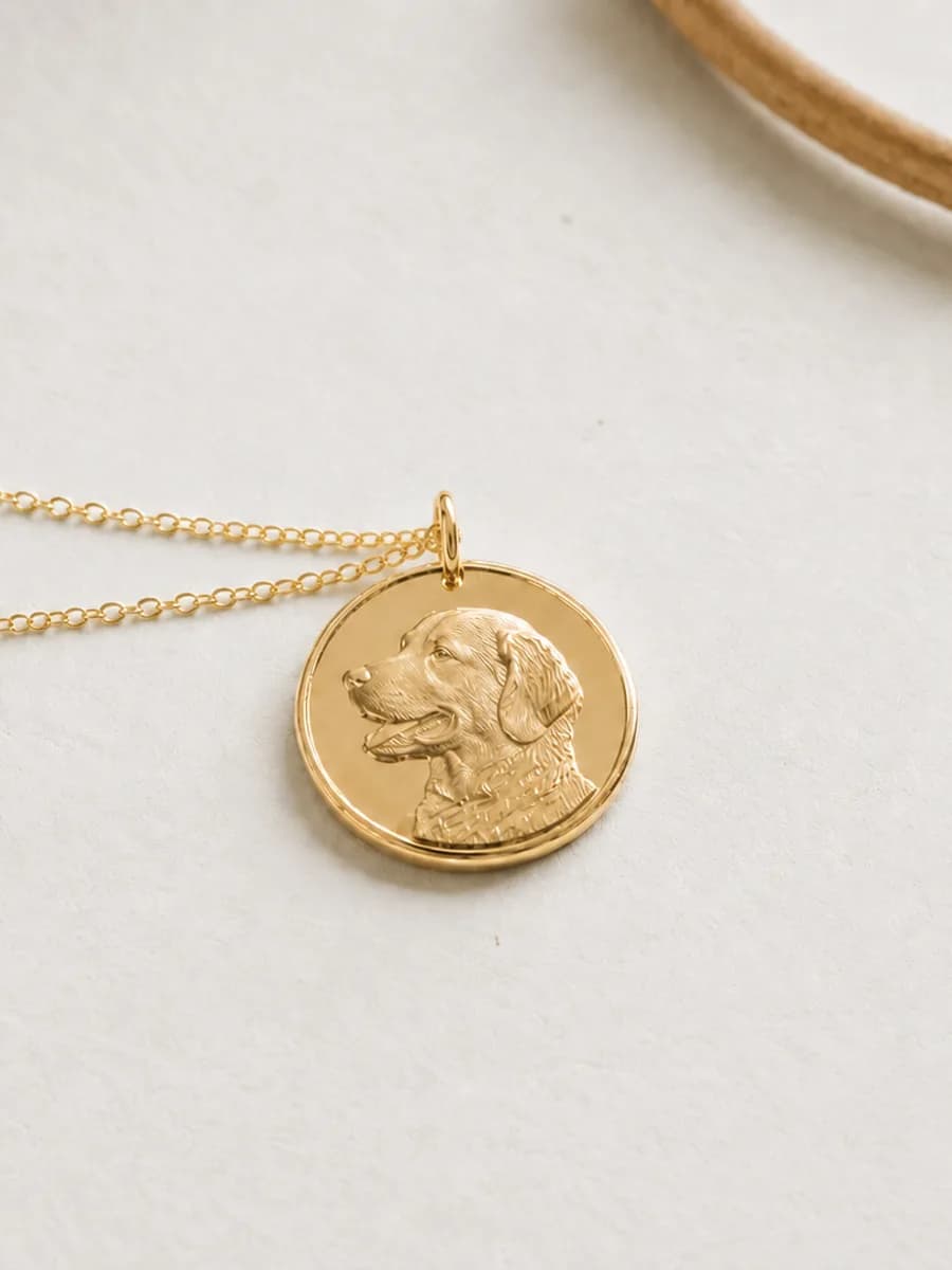 Gold pendant engraved with a golden retriever's head, on a fine gold chain