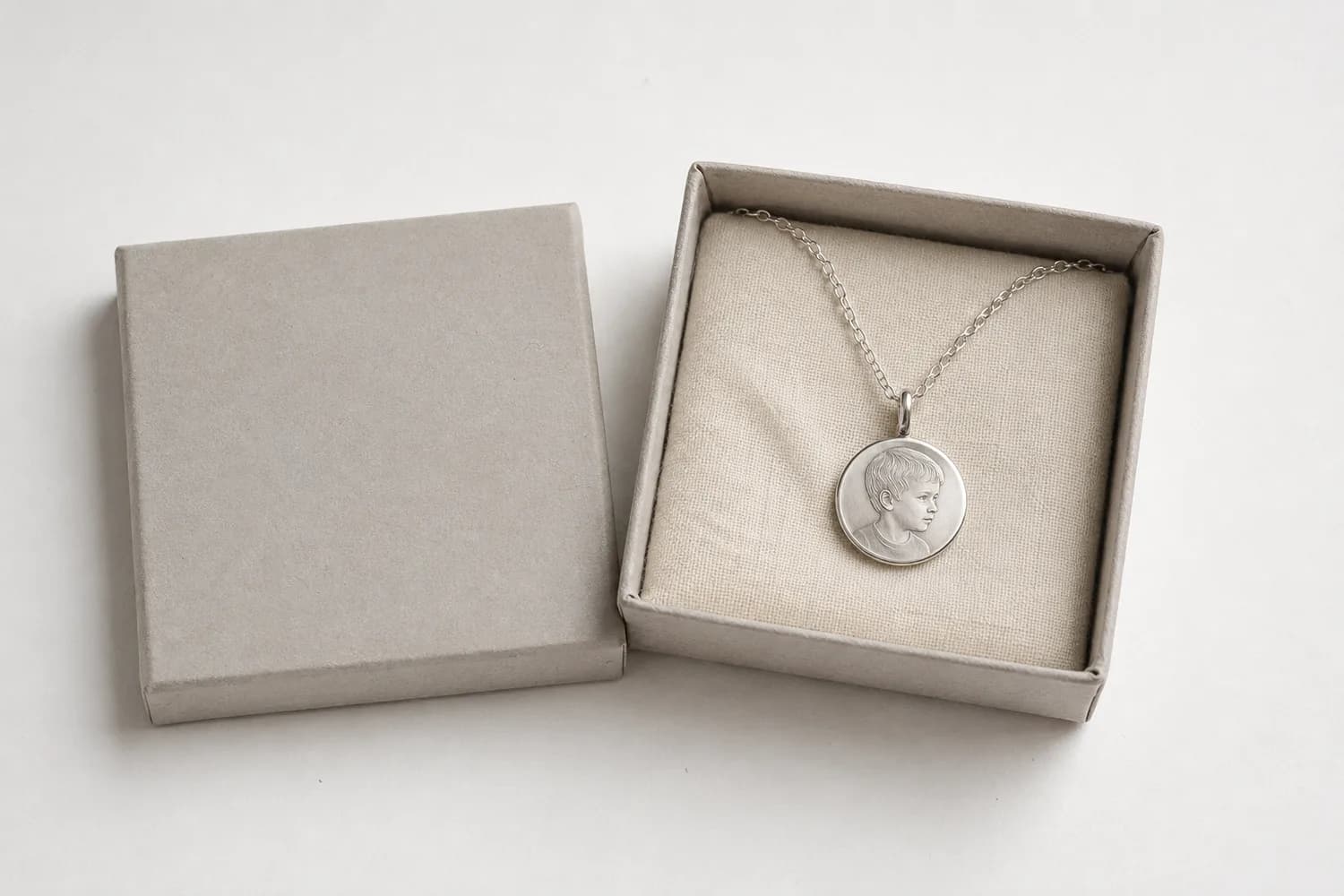 Silberner Anhänger mit Fotogravur an feiner Kette in seiner offenen, unbedruckten Geschenkschachtel